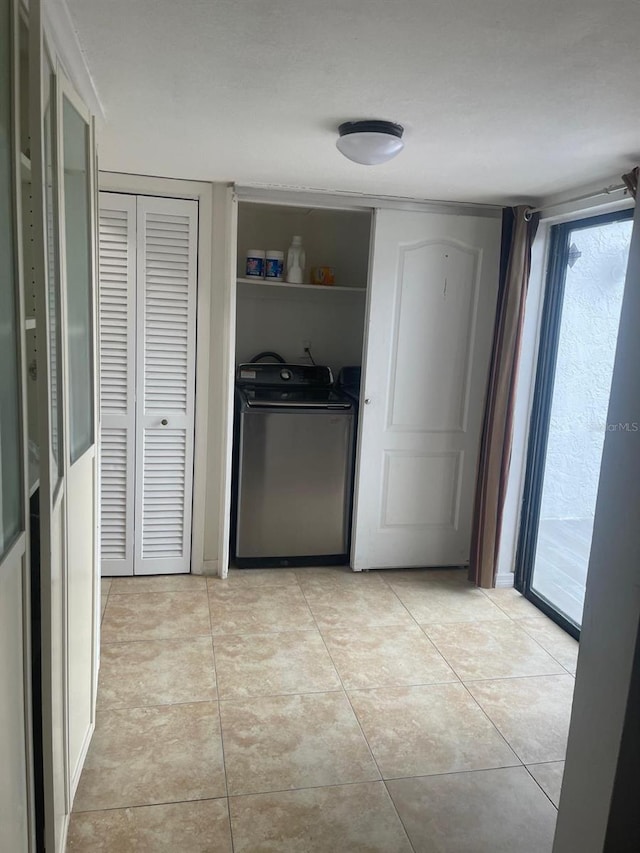 clothes washing area with light tile patterned floors and washing machine and clothes dryer