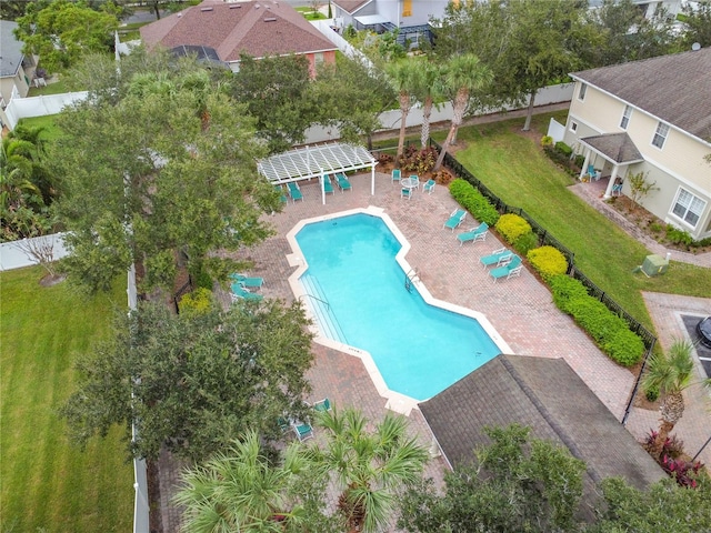 community pool with a patio area and fence