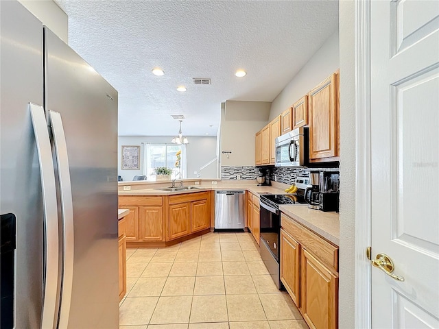 kitchen with light tile patterned floors, light countertops, visible vents, appliances with stainless steel finishes, and a sink