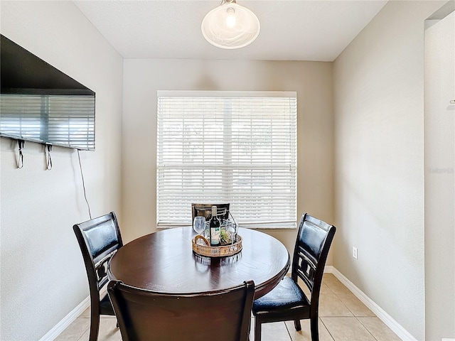 dining space featuring baseboards and light tile patterned flooring