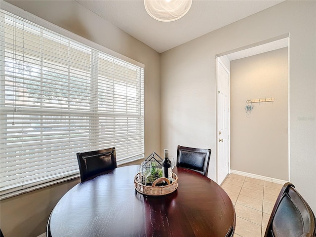 dining area featuring light tile patterned floors and baseboards