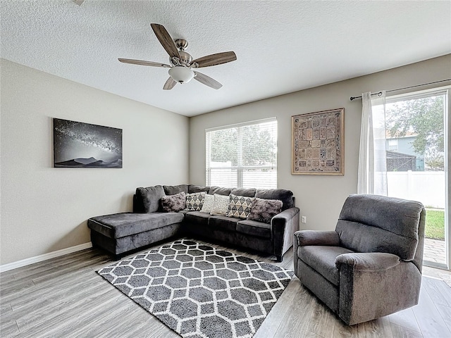 living room with plenty of natural light, a textured ceiling, and wood finished floors