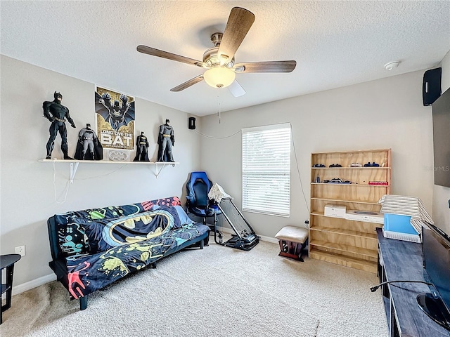 carpeted bedroom with a textured ceiling, baseboards, and a ceiling fan