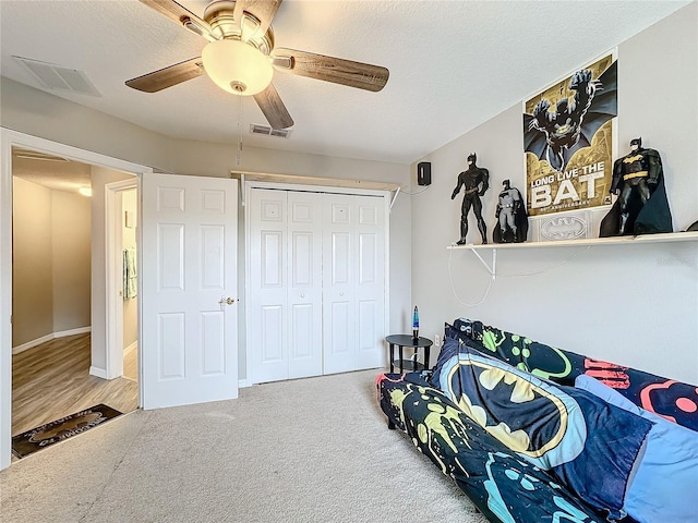 bedroom with a textured ceiling, visible vents, and carpet flooring