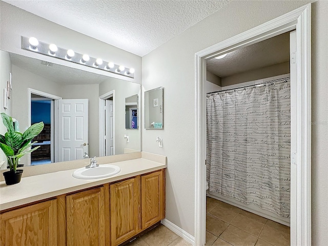 bathroom with a shower with shower curtain, tile patterned flooring, a textured ceiling, and vanity