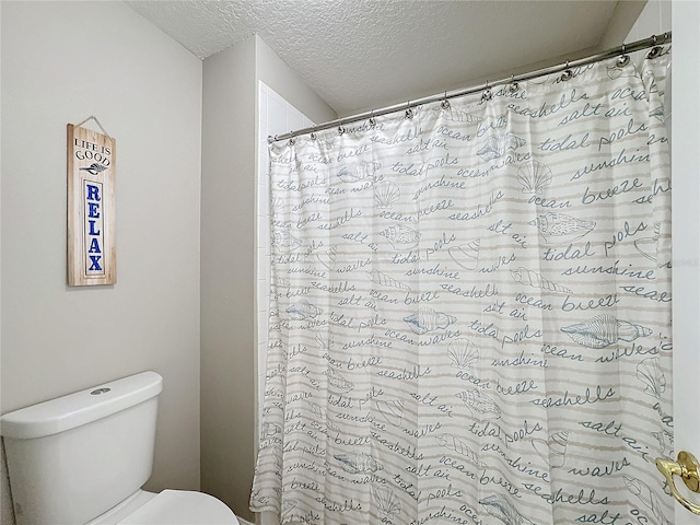 bathroom featuring a shower with shower curtain, a textured ceiling, and toilet