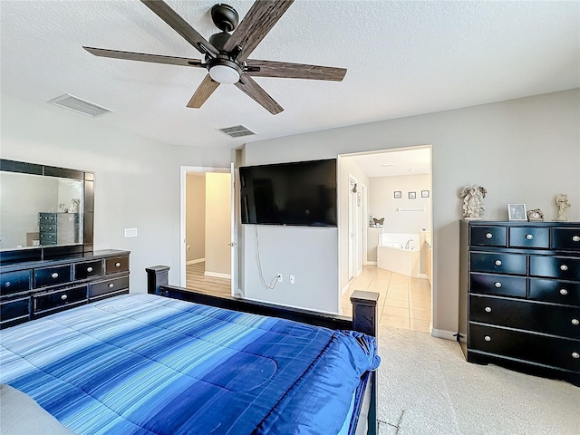 carpeted bedroom featuring a textured ceiling, ensuite bath, visible vents, and a ceiling fan