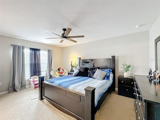 bedroom featuring light colored carpet, ceiling fan, a textured ceiling, and baseboards