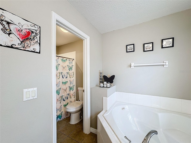 bathroom featuring toilet, a garden tub, tile patterned flooring, and a textured ceiling