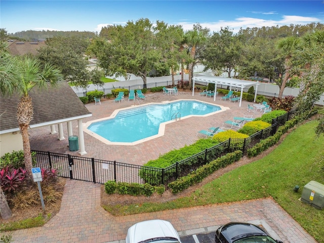 community pool featuring a patio, a yard, and fence