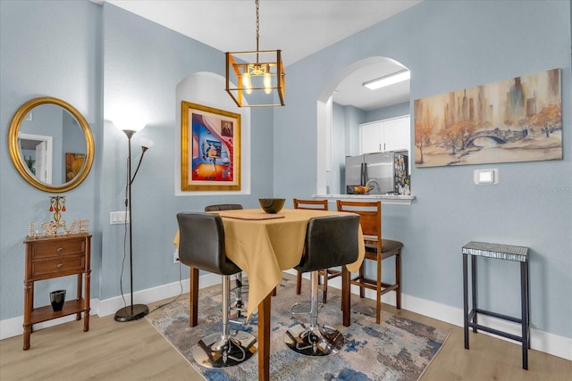 dining area with a chandelier and light hardwood / wood-style floors