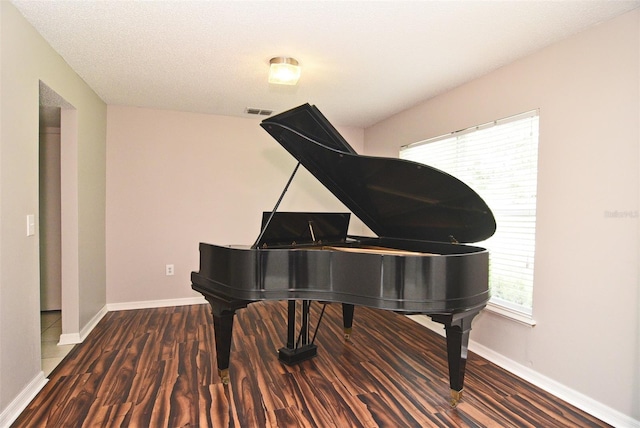 miscellaneous room with dark wood-type flooring and a textured ceiling