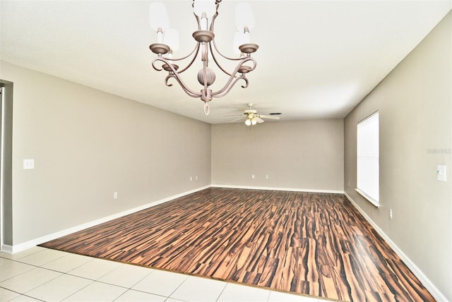 spare room featuring light wood-type flooring and ceiling fan with notable chandelier