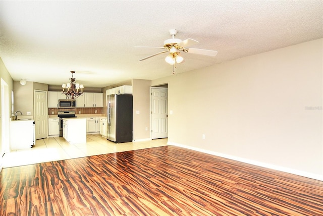 kitchen featuring light hardwood / wood-style flooring, a textured ceiling, sink, white cabinetry, and appliances with stainless steel finishes