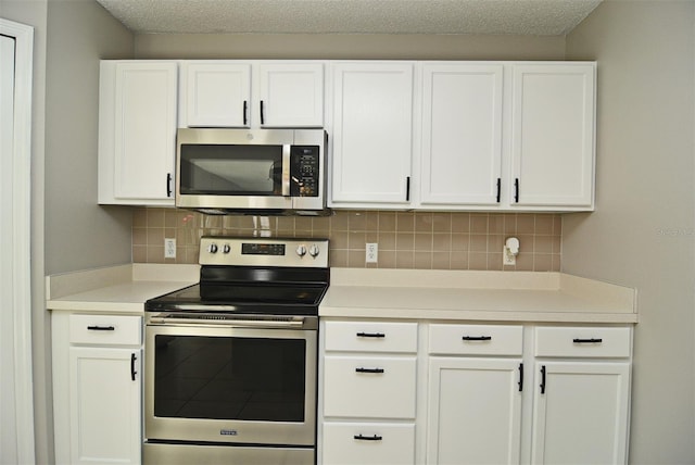 kitchen with white cabinets, decorative backsplash, and appliances with stainless steel finishes