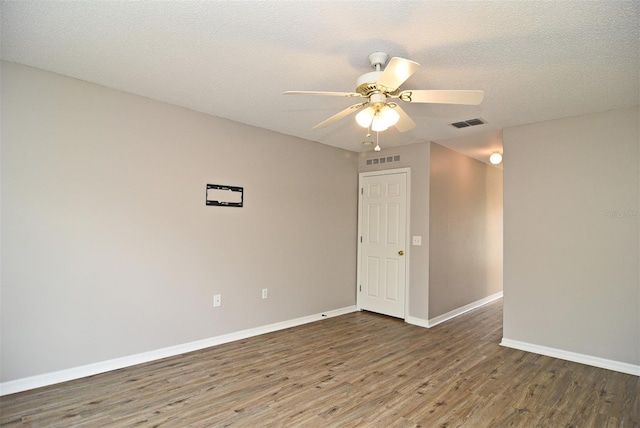 empty room with ceiling fan, a textured ceiling, and dark hardwood / wood-style floors