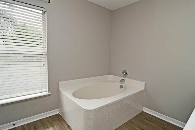 bathroom featuring hardwood / wood-style floors and tiled tub