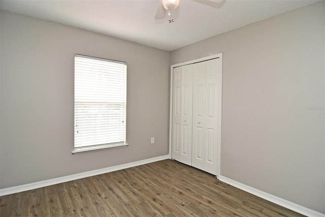 unfurnished bedroom with a closet, ceiling fan, and dark hardwood / wood-style floors