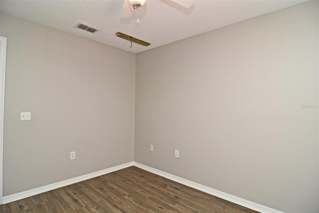 spare room featuring dark wood-type flooring, ceiling fan, and a textured ceiling