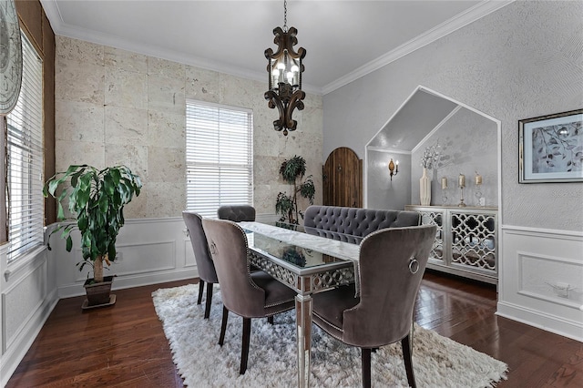 dining room featuring dark wood-type flooring, crown molding, and a notable chandelier