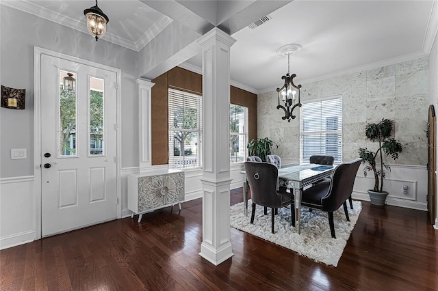 dining room featuring dark hardwood / wood-style floors, plenty of natural light, ornate columns, and a chandelier