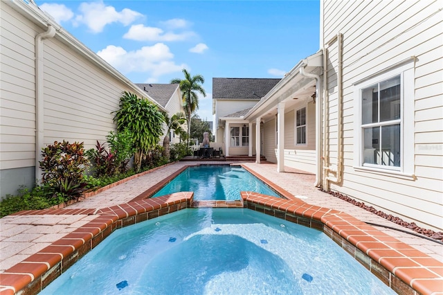 view of pool with a patio and an in ground hot tub