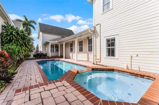 view of pool featuring a patio and an in ground hot tub