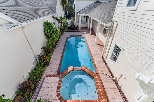 view of swimming pool featuring an in ground hot tub and a patio area