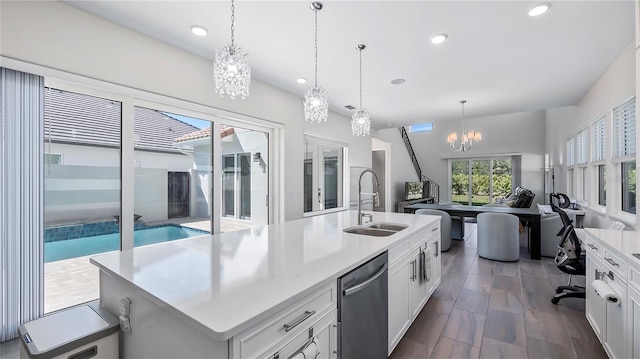 kitchen featuring dark hardwood / wood-style flooring, white cabinets, sink, a chandelier, and a kitchen island with sink