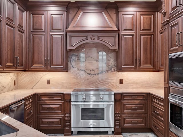 kitchen with tasteful backsplash, dark brown cabinetry, appliances with stainless steel finishes, and light stone countertops