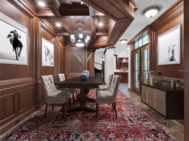 dining area with beam ceiling, ornamental molding, coffered ceiling, a decorative wall, and a chandelier