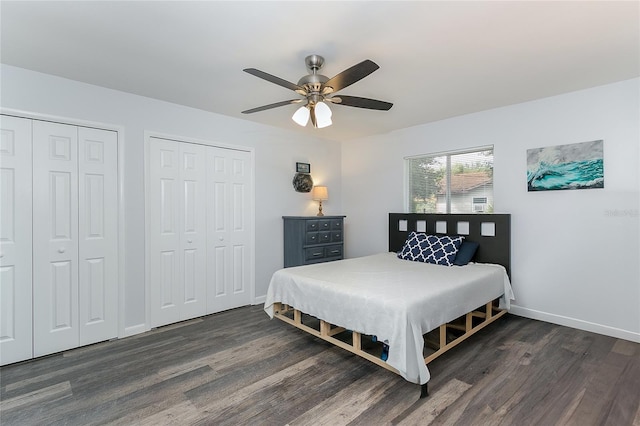 bedroom featuring ceiling fan, dark wood-type flooring, and two closets