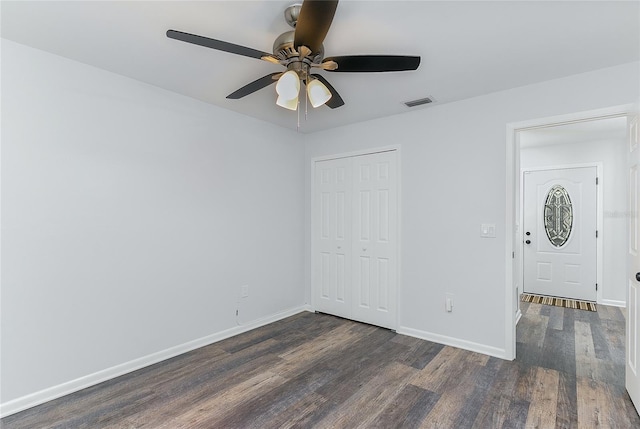 unfurnished bedroom featuring a closet, ceiling fan, and dark hardwood / wood-style flooring