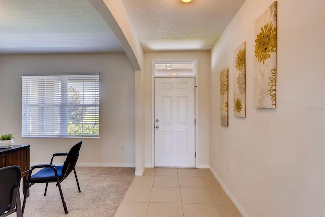 tiled entryway with a textured ceiling