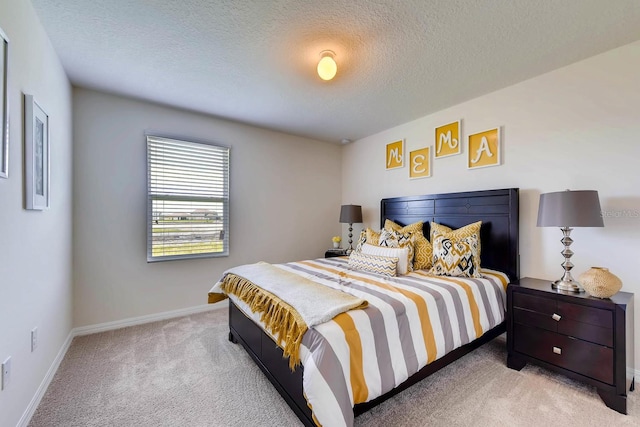 bedroom with a textured ceiling and light carpet