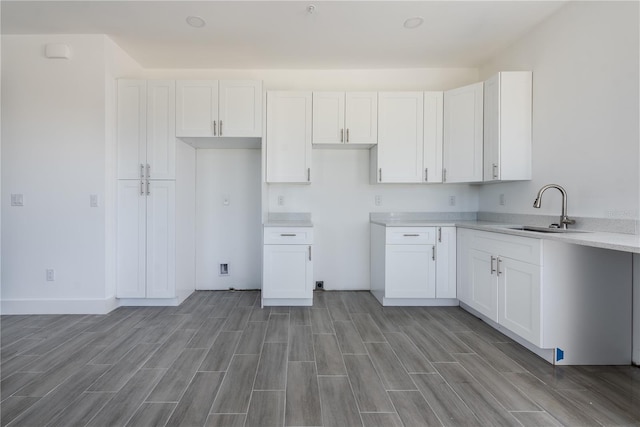 kitchen featuring white cabinets, light hardwood / wood-style floors, and sink