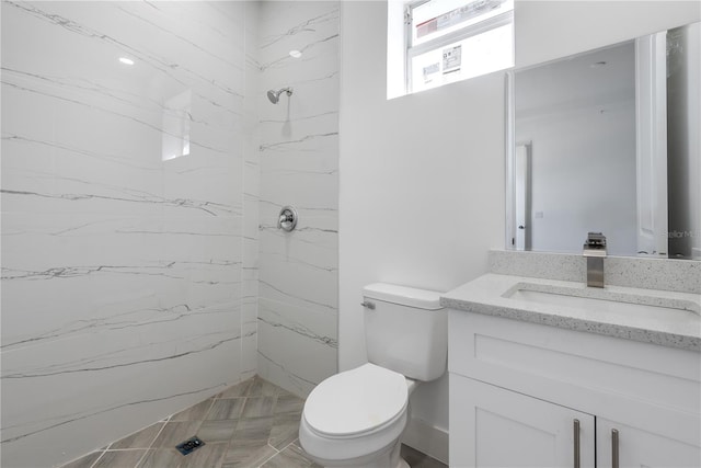 bathroom featuring vanity, toilet, and tiled shower