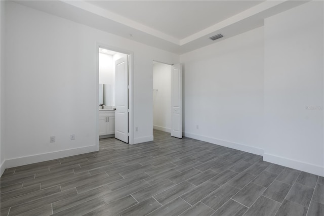 unfurnished bedroom with hardwood / wood-style floors and ensuite bath