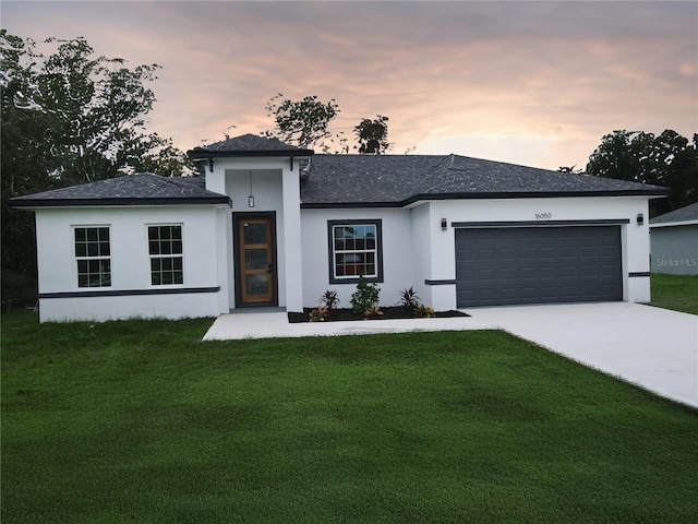 view of front of home featuring a lawn and a garage