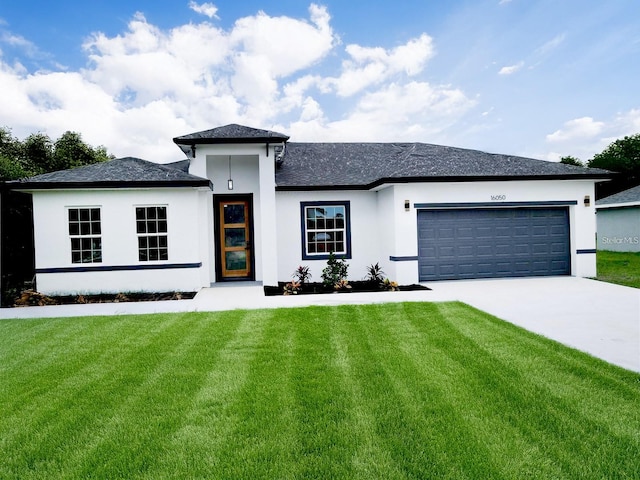 prairie-style home with concrete driveway, stucco siding, an attached garage, and a front yard