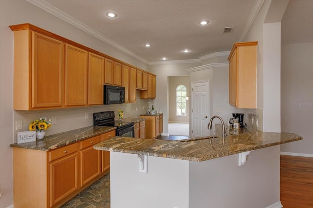 kitchen with black appliances, kitchen peninsula, a breakfast bar, and crown molding