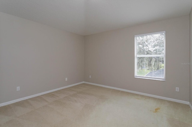 unfurnished room featuring light carpet