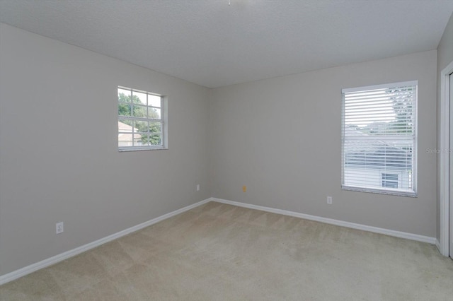 carpeted empty room with a textured ceiling