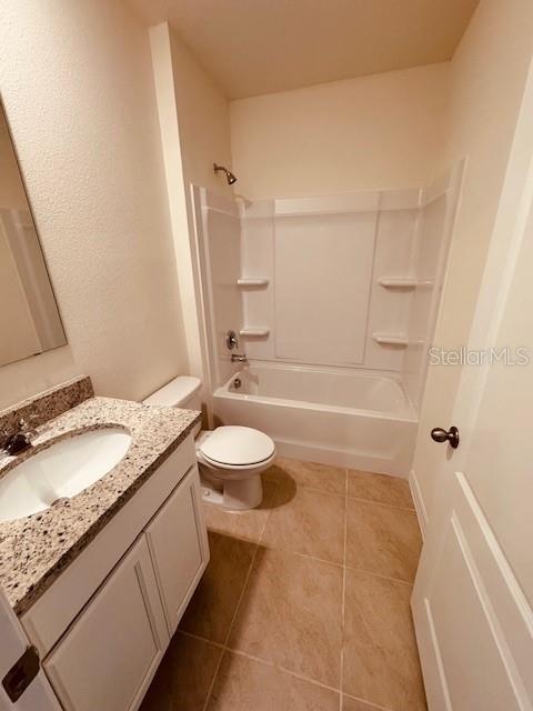 full bathroom with tile patterned floors, vanity, toilet, and shower / washtub combination