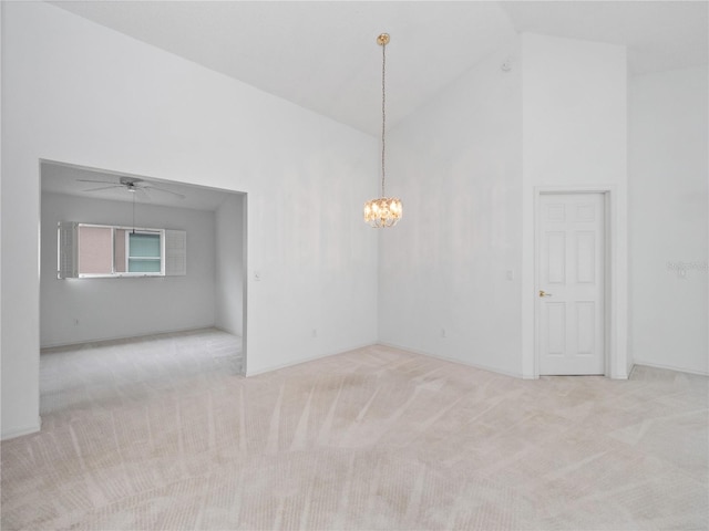 unfurnished room featuring light colored carpet, ceiling fan with notable chandelier, and high vaulted ceiling