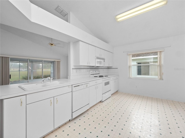 kitchen with plenty of natural light, lofted ceiling, sink, and white appliances