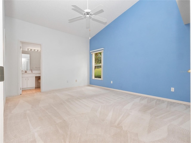 unfurnished bedroom with high vaulted ceiling, light carpet, ceiling fan, and connected bathroom