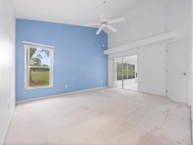 carpeted spare room with a towering ceiling and ceiling fan