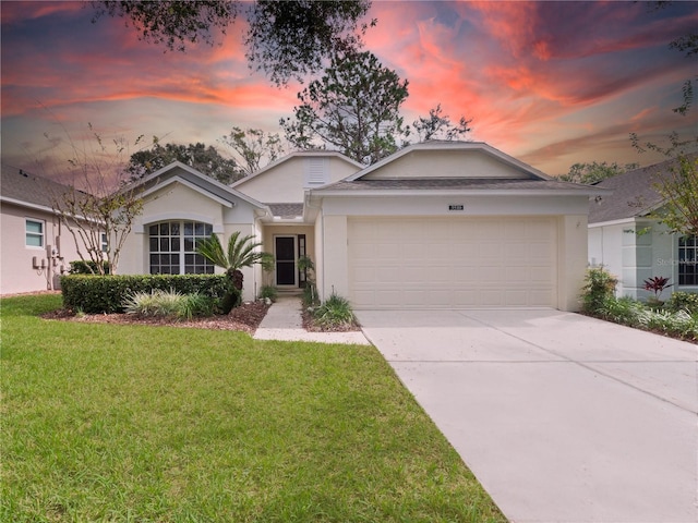 ranch-style house featuring a garage and a yard