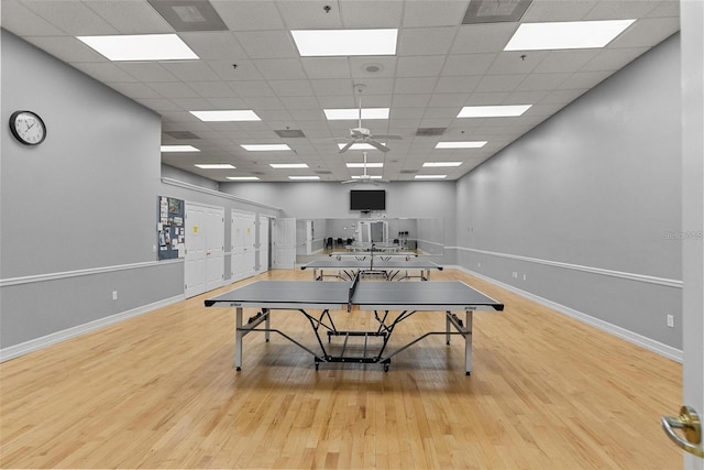 playroom with a drop ceiling and light wood-type flooring